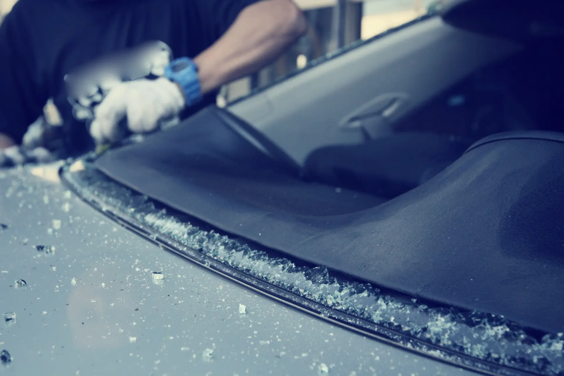 Technician removing a broken windscreen with shattered glass